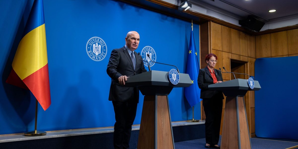 Premierul Ilie Bolojan și Ioana Ene Dogioiu, purtătoarea de cuvânt a Guvernului. Foto: Guvernul României