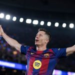 Dwóch piłkarzy w sportowych strojach z opuszczonymi głowami, jeden trzyma dłoń przy twarzy, drugi ma ręce na biodrach. Ich wyraz twarzy i postawa sugerują rozczarowanie bądź smutek po wydarzeniach na boisku.